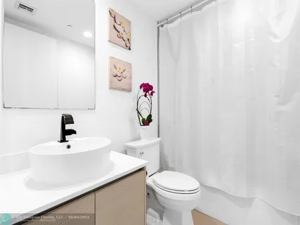 a bathroom with a sink a toilet and shower curtain