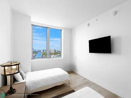 a bedroom with a bed tv and a window