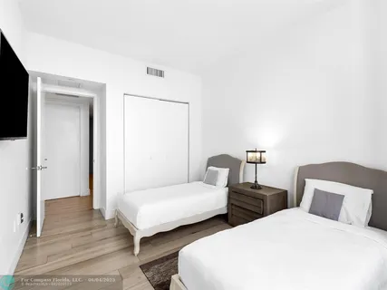 a bedroom with two beds and a night stand