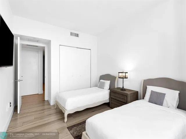 a bedroom with two beds and a night stand