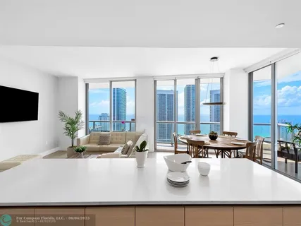 a living room with large window and flat screen tv