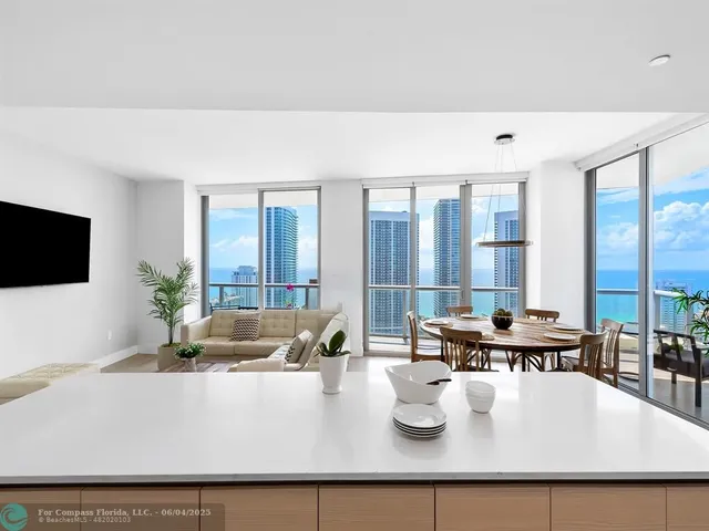 a living room with large window and flat screen tv