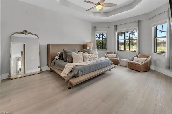 a spacious bedroom with a bed a couch and dresser