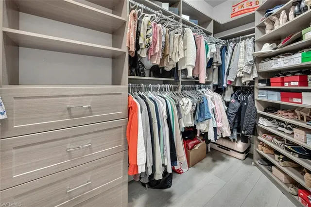 a view of walk in closet with clothes and shoes