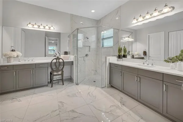 a spacious bathroom with a granite countertop sink a toilet a mirror and shower