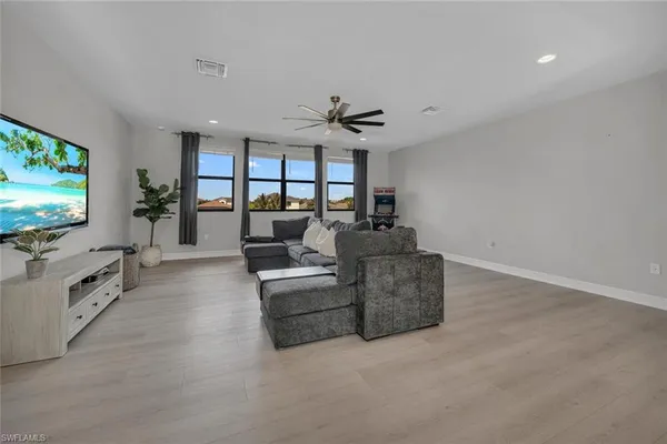 a bedroom with a bed lamp and windows