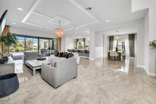 a living room with couches and kitchen view with wooden floor