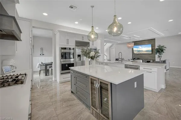 a kitchen with stainless steel appliances granite countertop a sink a stove and a wooden floors