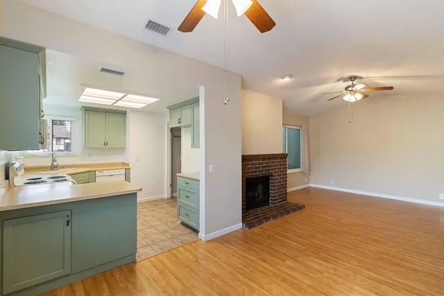 a view of kitchen with sink and refrigerator