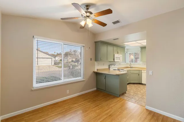 a view of an empty room with a kitchen and a window