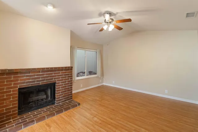a view of a livingroom with a fireplace and wooden floor