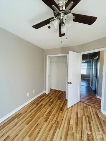 a view of a room with wooden floor and ceiling fan