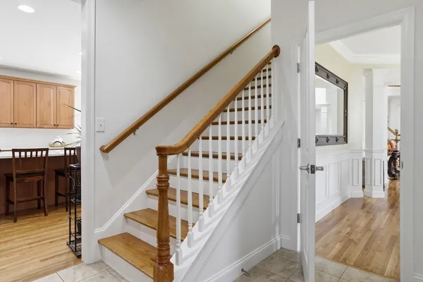 a view of staircase with lots of frames on wall and wooden floor