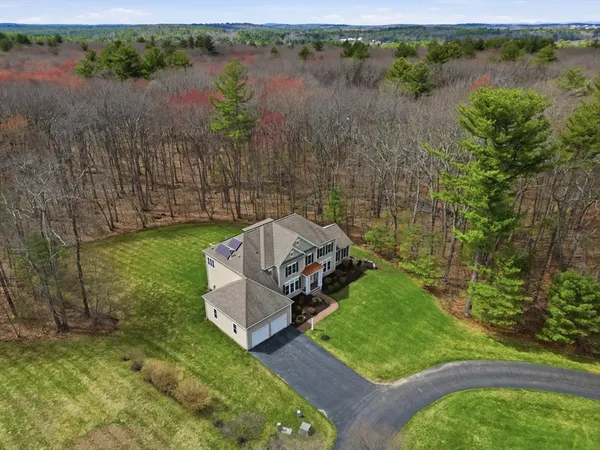 an aerial view of a house with a yard and lake view