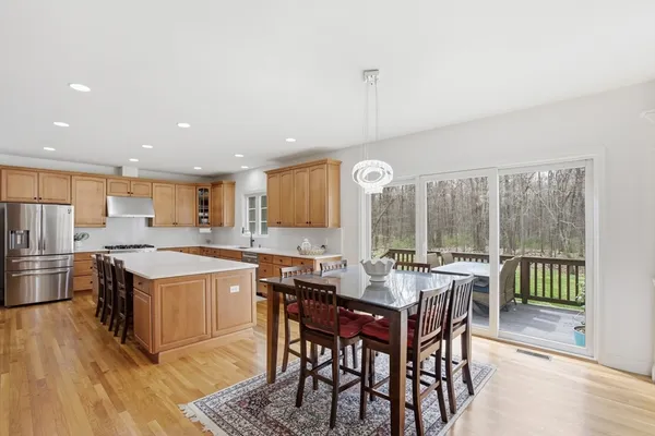 a kitchen with a stove a sink a dining table and chairs
