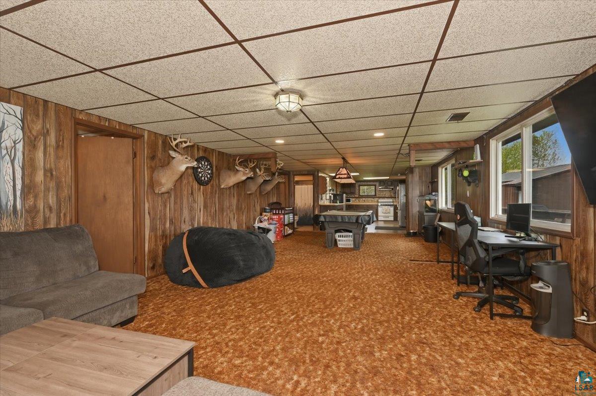 5190 County Road M Gordon, WI 54838 - Photo 15 of 31 Expansive interior space featuring wood paneling, a drop ceiling with recessed lighting, and multiple windows