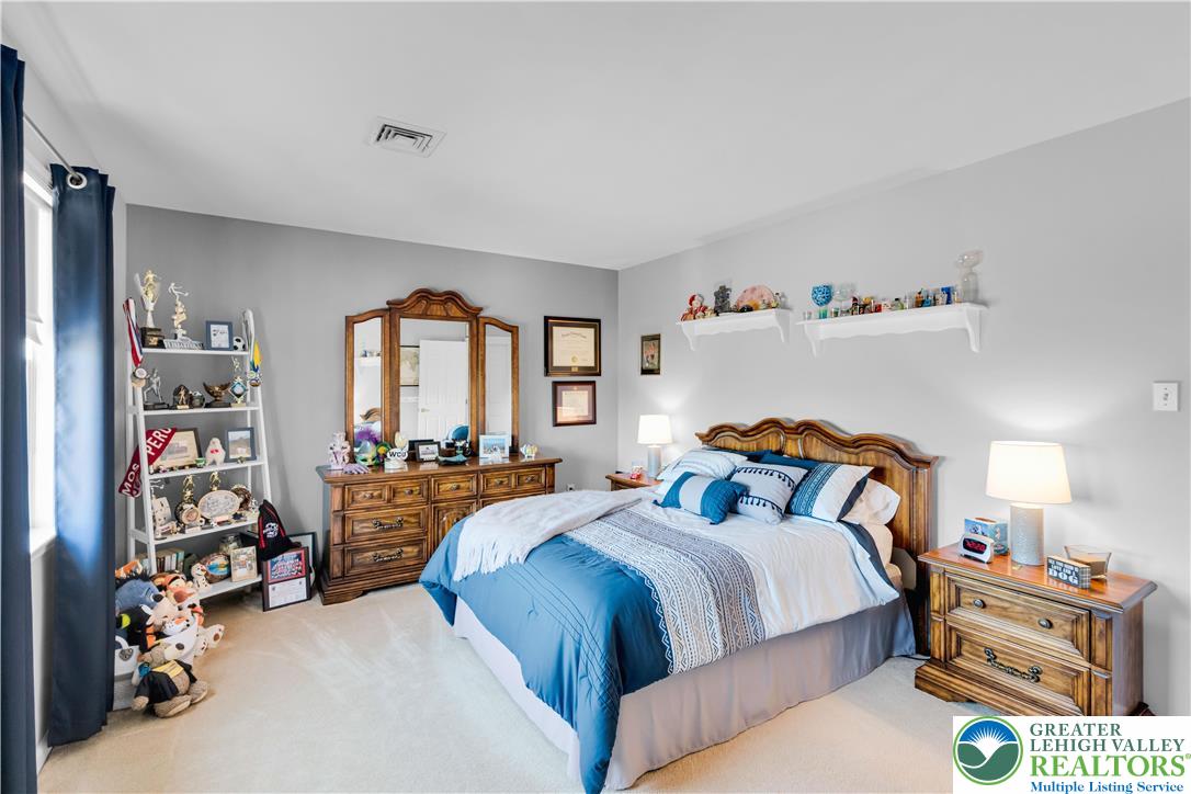 4059 Old Sentry Road Allentown, PA 18104 - Photo 25 of 39 A comforting bedroom awaits, featuring soft carpeting and a classic wooden bed frame for peaceful slumber.
