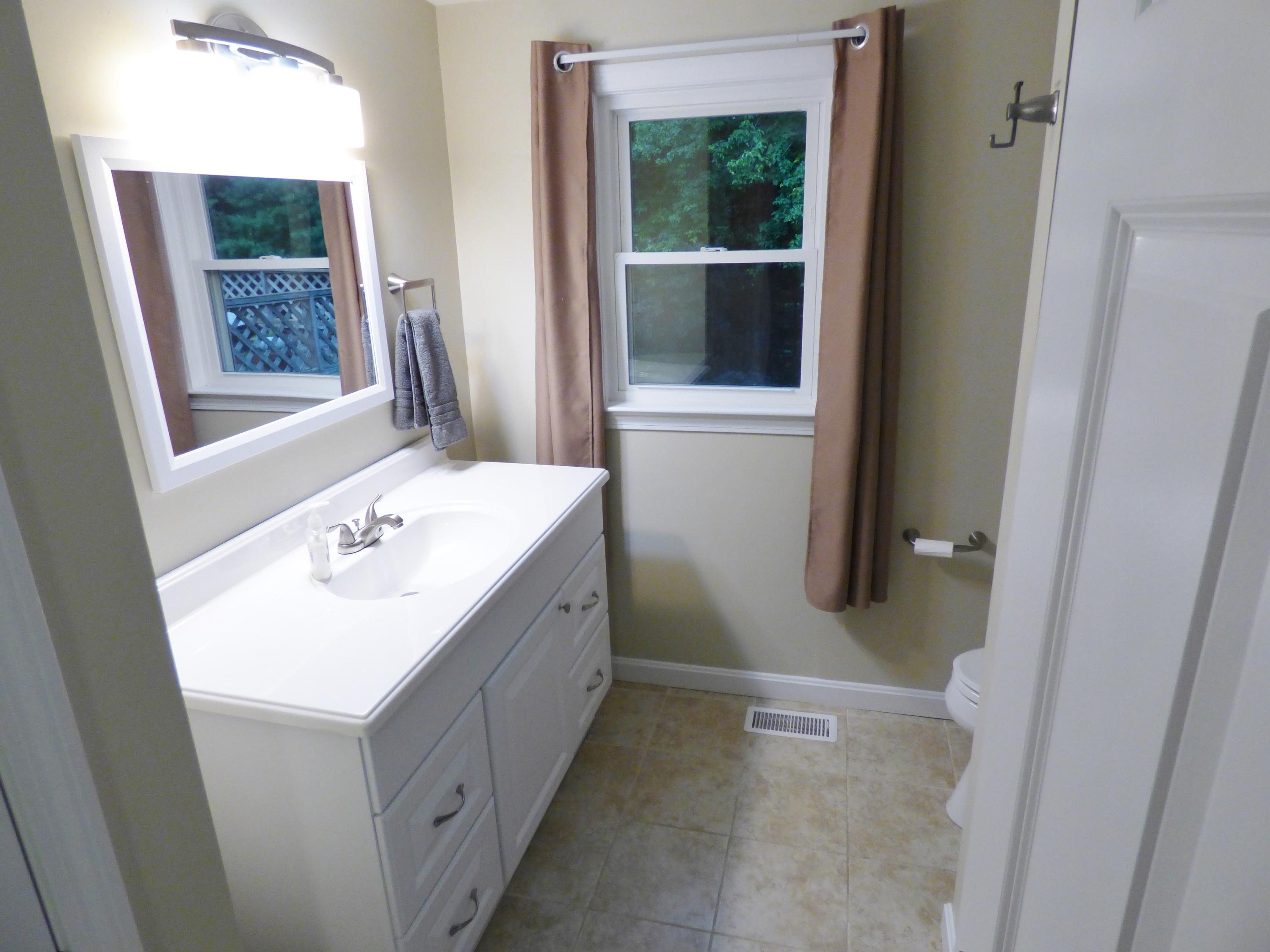 100 Taramac Road Centerville, MA 02632 - Photo 6 of 18 a bathroom with a sink a mirror and a bathtub