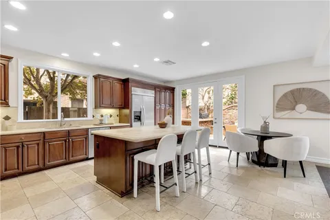 a large kitchen with lots of furniture a sink and dining table chair
