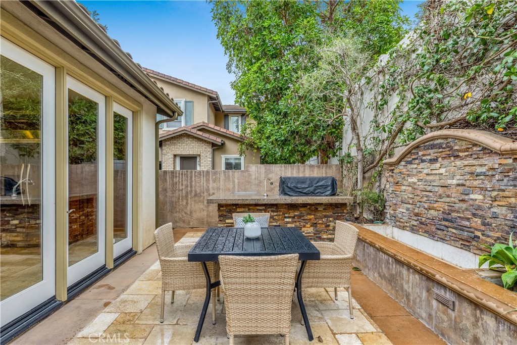 2105 Canyon Circle Costa Mesa, CA 92627 - Photo 20 of 35 a view of a patio with table and chairs and wooden floor