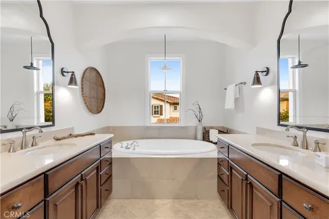 a bathroom with a double vanity sink mirror and bathtub