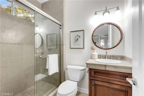 a bathroom with a granite countertop sink a toilet and a mirror