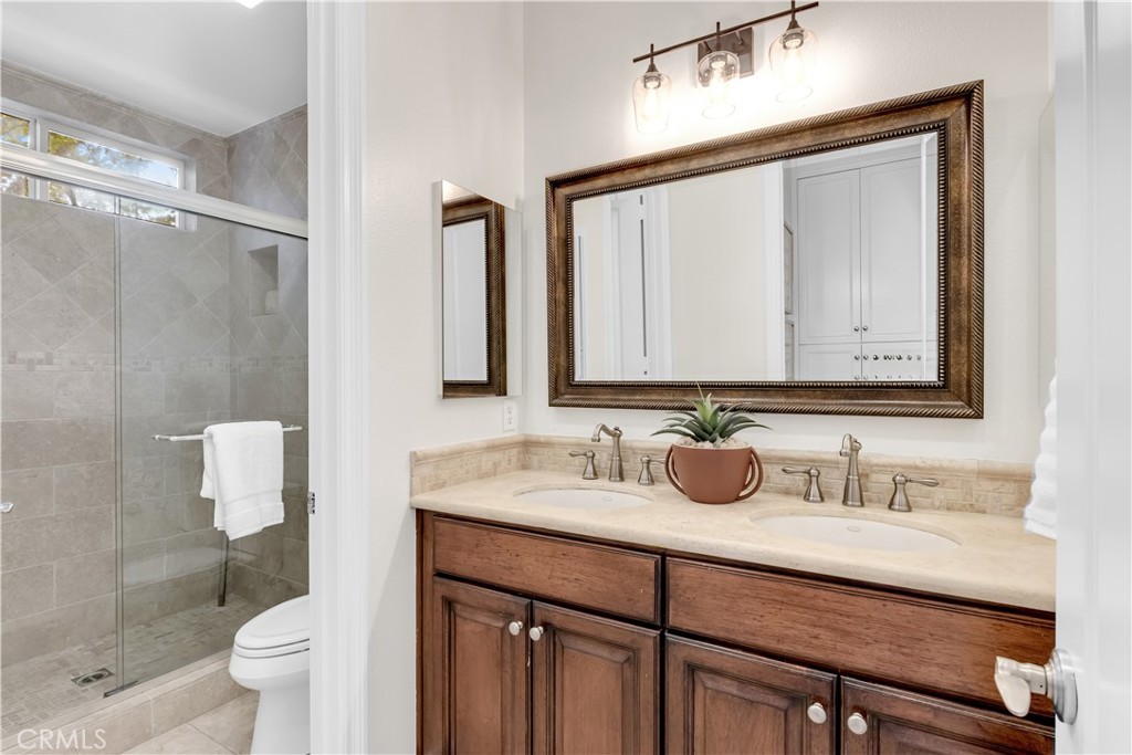 2105 Canyon Circle Costa Mesa, CA 92627 - Photo 32 of 35 a bathroom with a granite countertop sink a toilet and a mirror