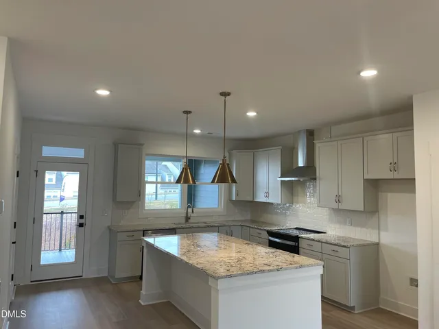 a kitchen with stainless steel appliances granite countertop a sink stove and cabinets