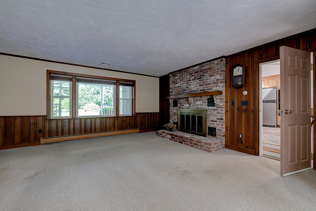 32 Bayberry Road Groton, MA 01450 - Photo 9 of 30 an empty room with floor to ceiling window and fireplace