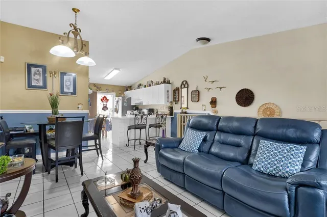 a living room with furniture kitchen view and a chandelier