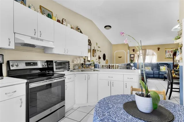 a kitchen with a stove a sink and cabinets