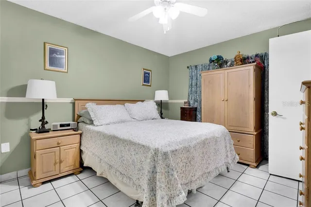 a bedroom with a bed and a refrigerator