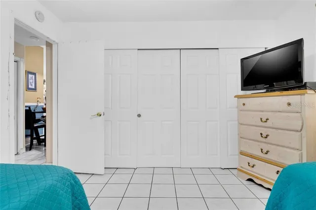 a view of a bedroom with cabinet flat screen tv and windows