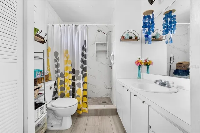 a bathroom with a sink a toilet and a shower curtain