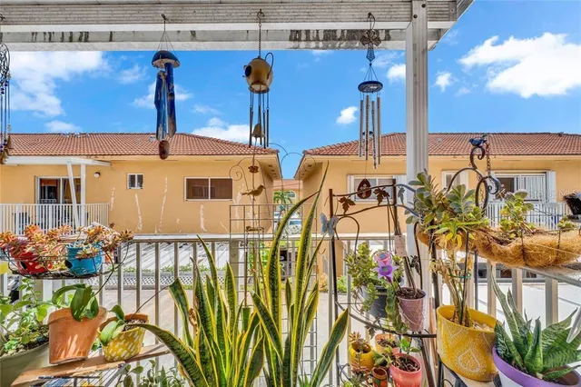 a view of a balcony with chairs and potted plants