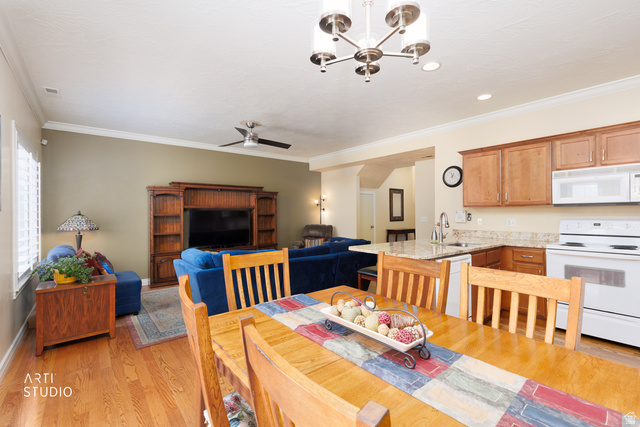 6761 950 East Midvale, UT 84047 - Photo 11 of 44 Open-concept living space with wood-finish flooring, a contemporary ceiling fan, and crown molding