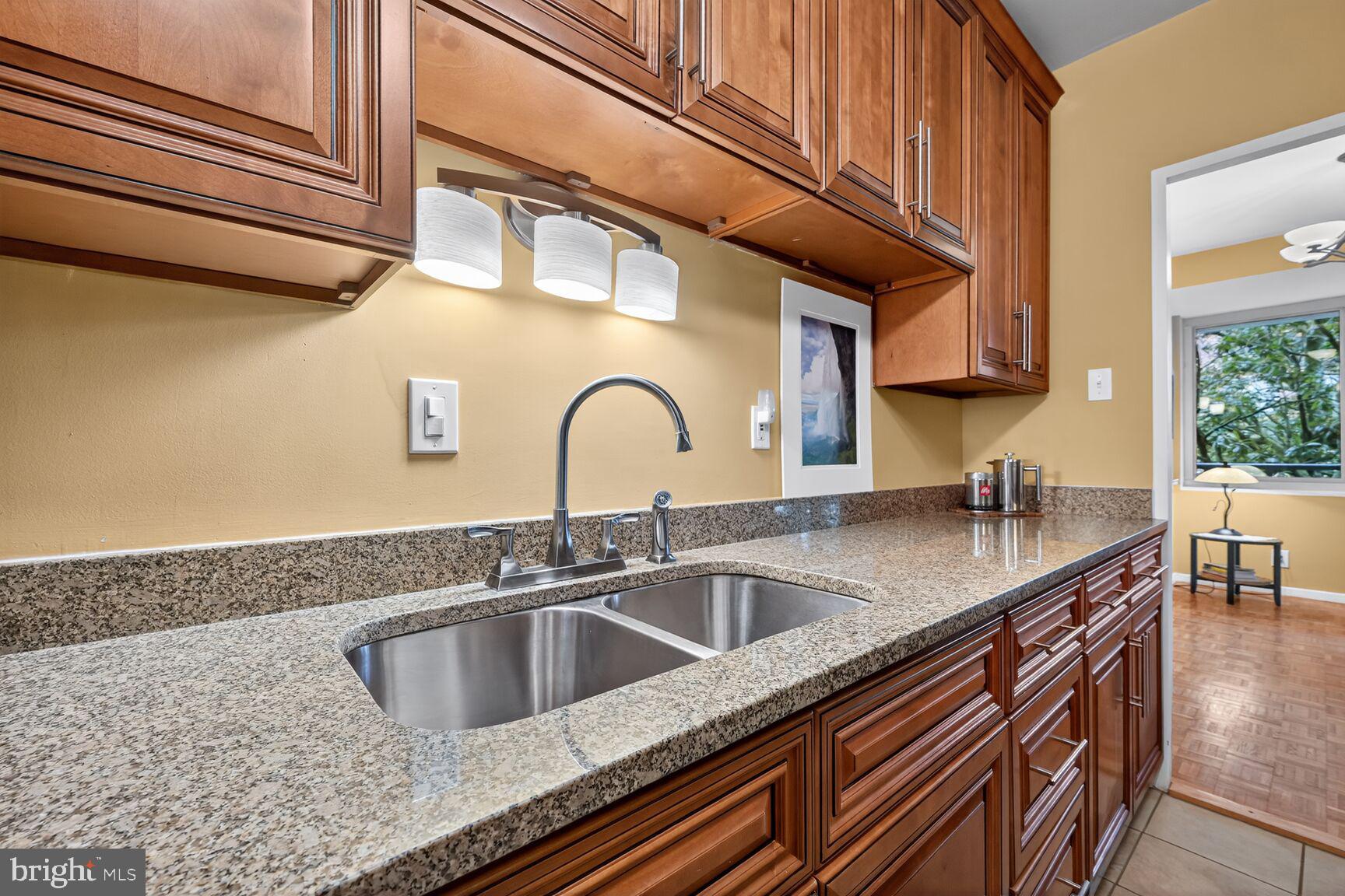 3900 Watson Place Northwest, Unit B1G Washington, DC 20016 - Photo 8 of 16 a kitchen with stainless steel appliances granite countertop a sink and cabinets