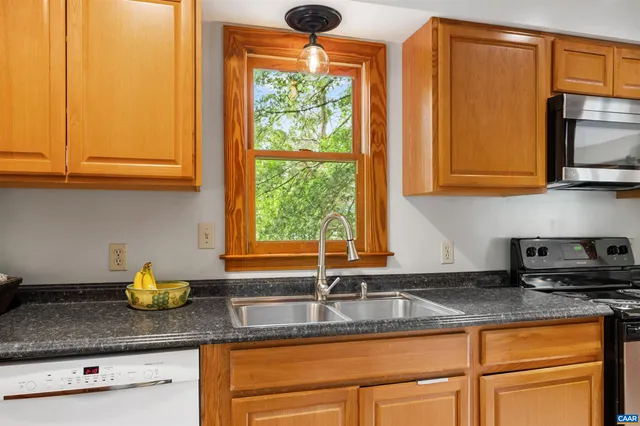 a kitchen with stainless steel appliances granite countertop a sink a granite counter tops and a wooden floors