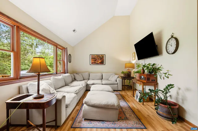 a living room with furniture a flat screen tv and a large window