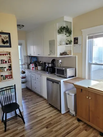 a kitchen with a sink cabinets and wooden floor