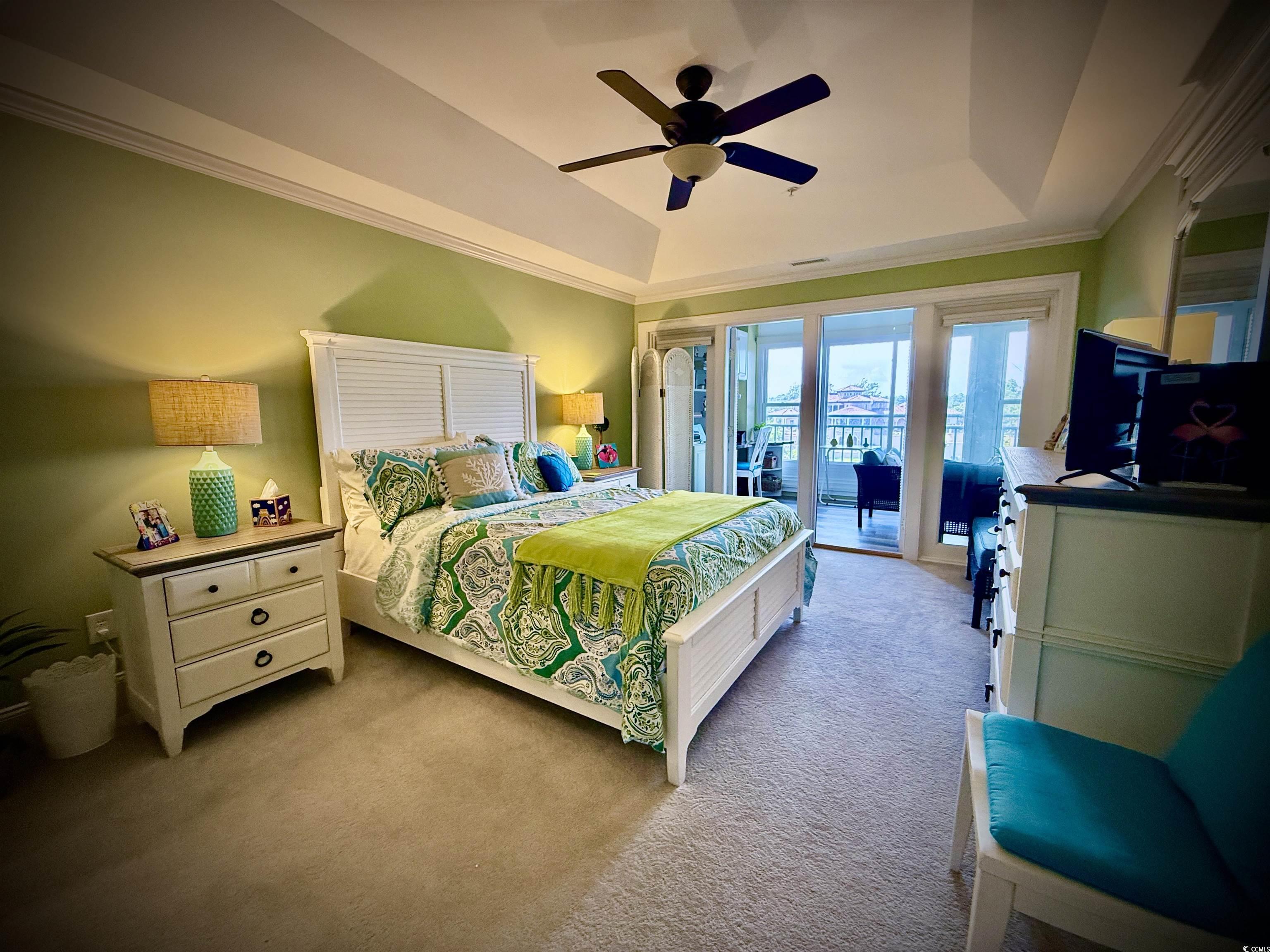 1330 Villa Marbella Court, Unit 303 Myrtle Beach, SC 29572 - Photo 18 of 40 Bedroom featuring a raised ceiling, access to outside, carpet flooring, ornamental molding, and ceiling fan