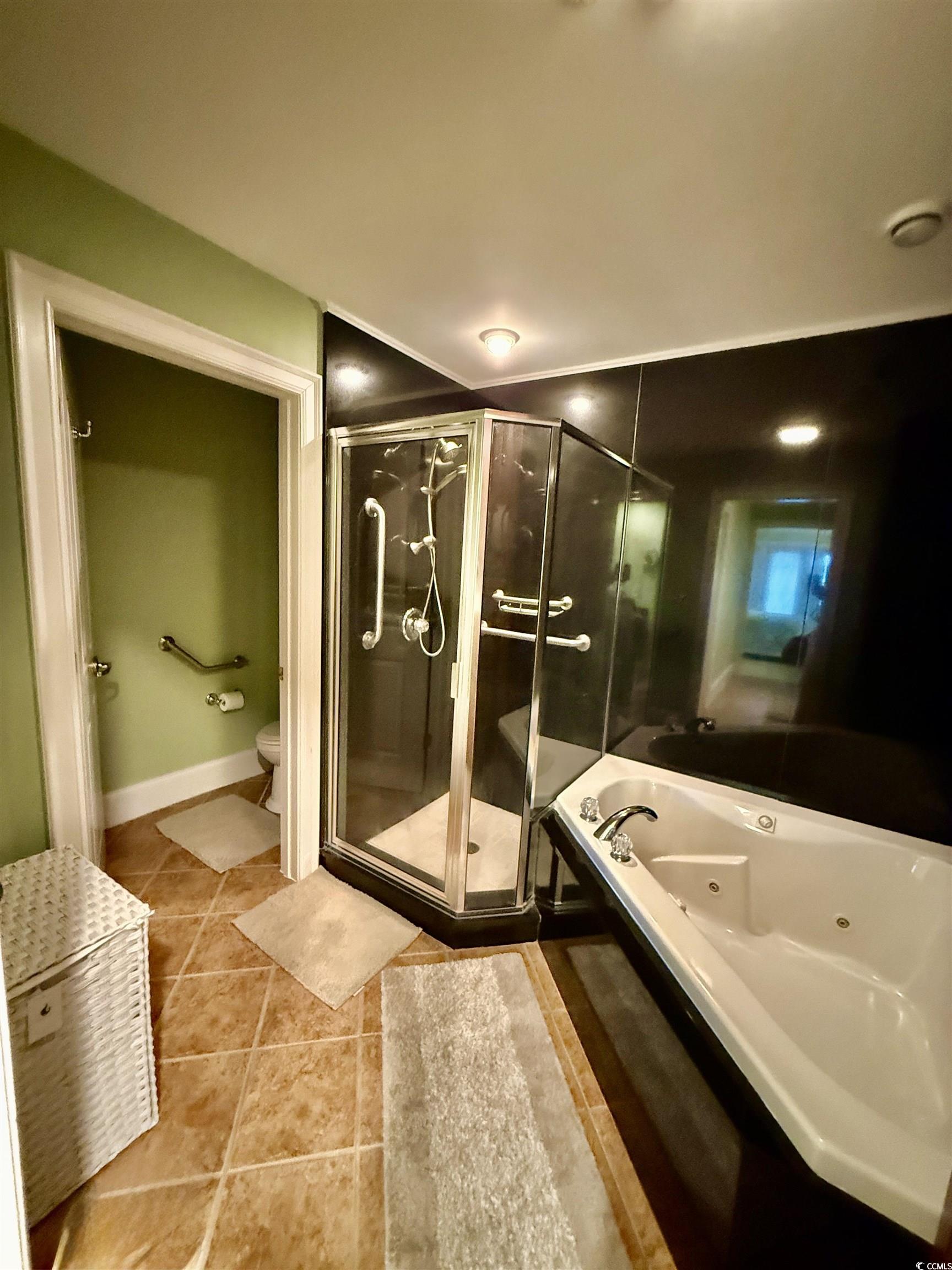 1330 Villa Marbella Court, Unit 303 Myrtle Beach, SC 29572 - Photo 20 of 40 Full bath with a whirlpool tub, a stall shower, and tile patterned flooring