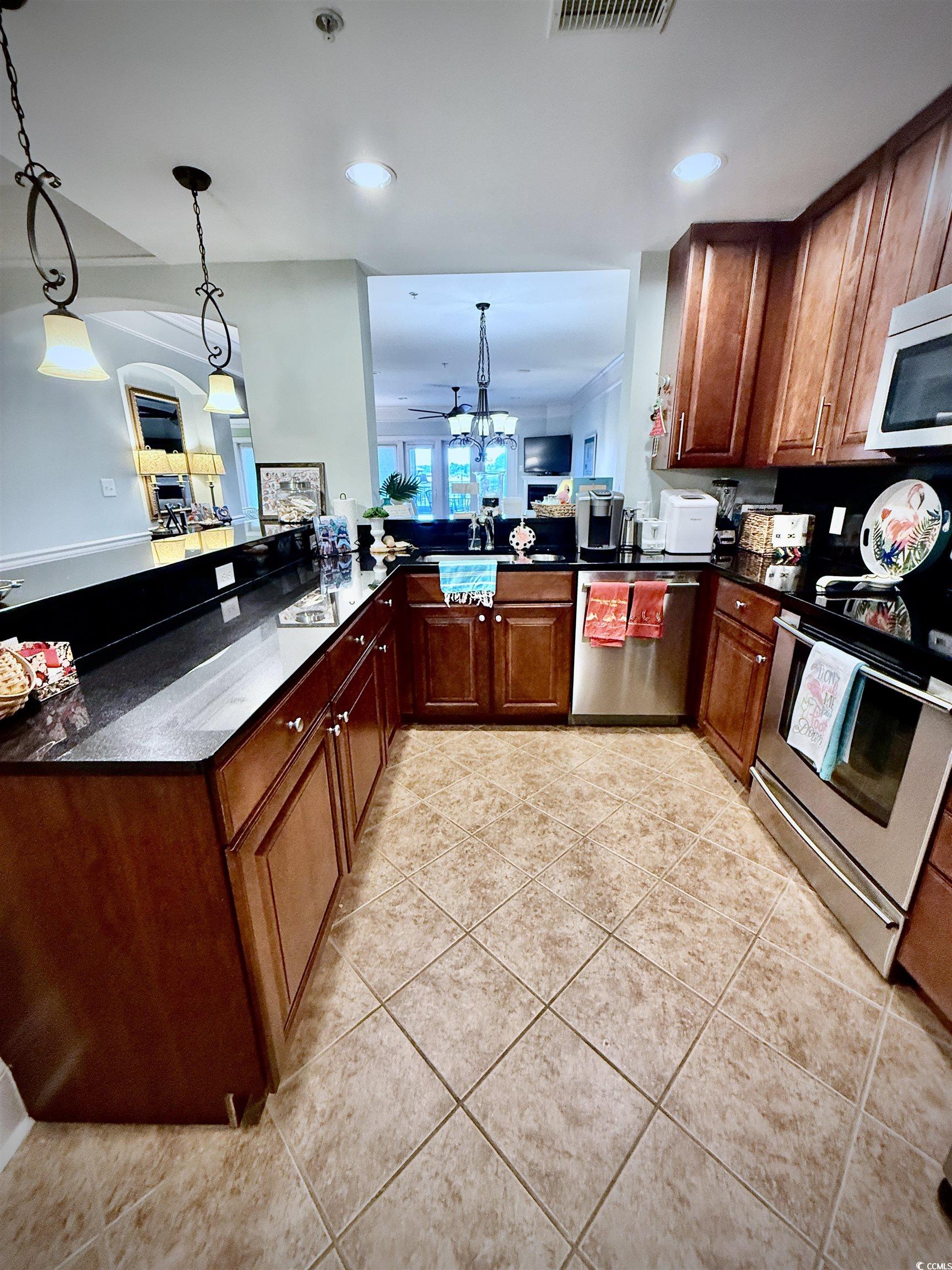 1330 Villa Marbella Court, Unit 303 Myrtle Beach, SC 29572 - Photo 4 of 40 Kitchen with light tile patterned floors, stainless steel appliances, hanging light fixtures, recessed lighting, and dark stone countertops