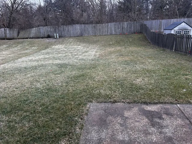 a view of a backyard with a fence