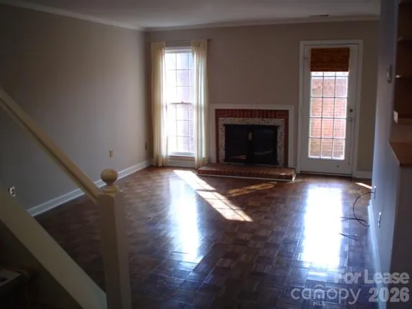 a view of a livingroom with wooden floor and a fireplace