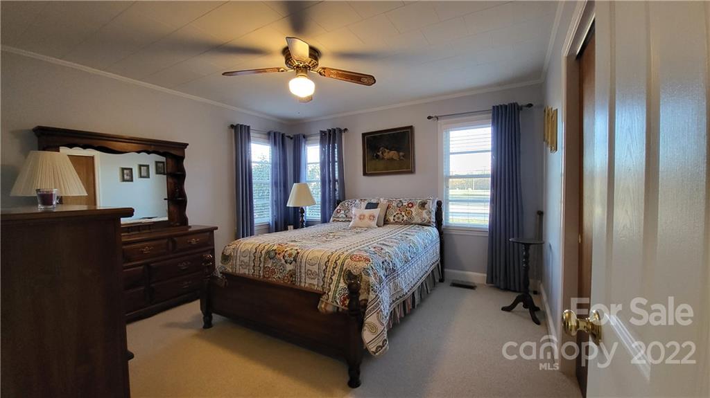 3518 Upper White Store Road Peachland, NC 28133 - Photo 26 of 33 a spacious bedroom with a bed and a chandelier