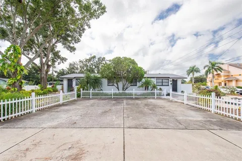 a view of a white house with large windows and a small yard