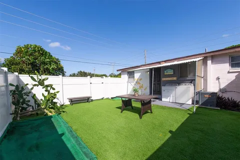 a backyard of a house with table and chairs