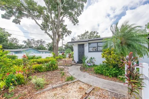 a view of a backyard with plants and swimming pool