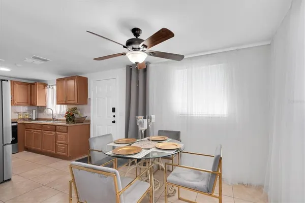 a kitchen with stainless steel appliances kitchen island granite countertop a table chairs in it and wooden floors